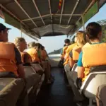 The Best Time to Visit Puerto Maldonado tourist in a jungle boat with life jackets